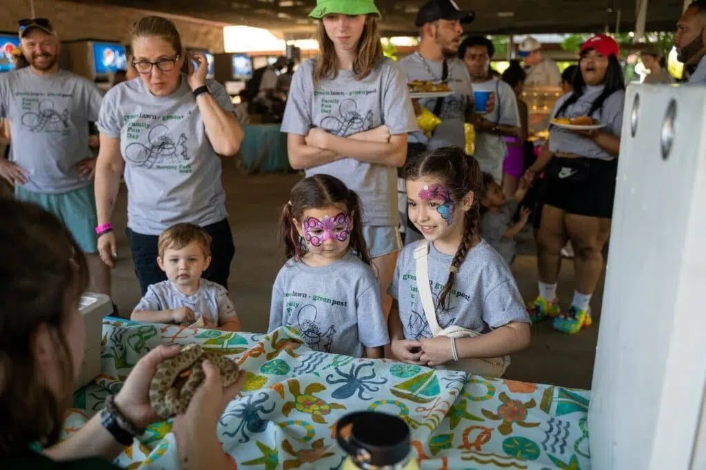 Team members are their children check out the petting zoo