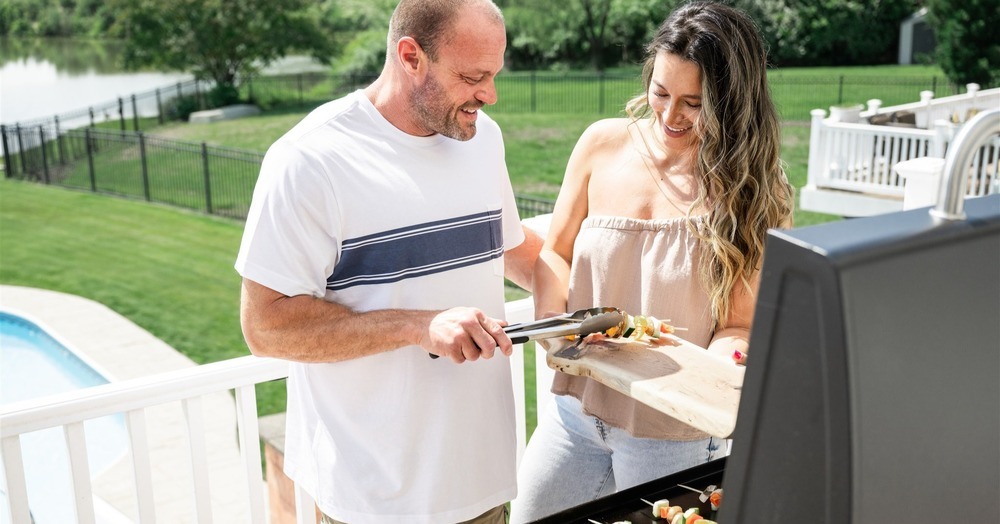 man and woman grilling outside