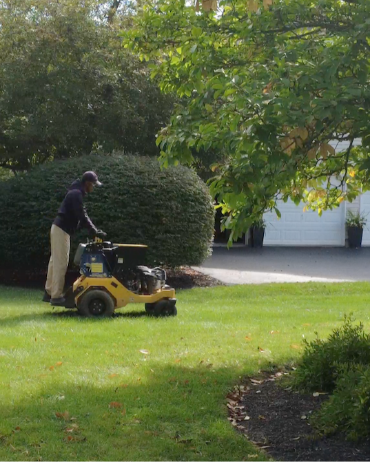 lawn technician performing aeration & seeding on a lawn