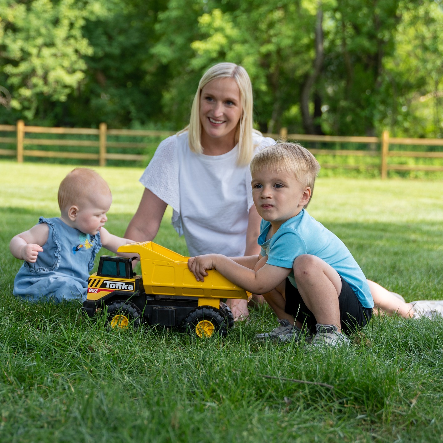 mom sitting in lawn with two children